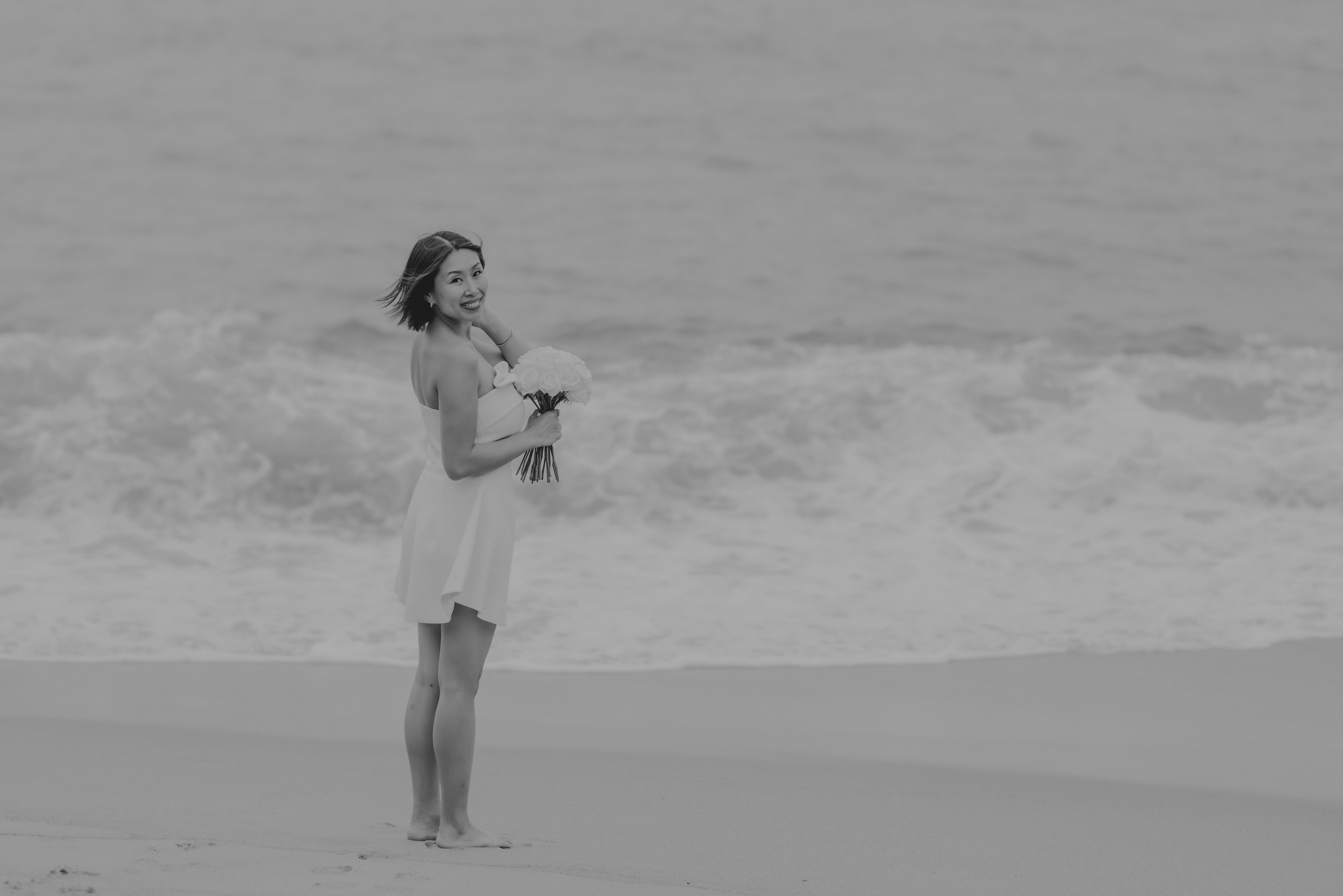 Woman walking on Kamakura Japan beach with temple in background